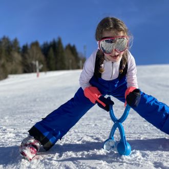 Child making snowballs in Les Gets
